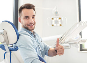 man giving thumbs up at the dentist
