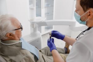 dentist showing male patient a model of an implant